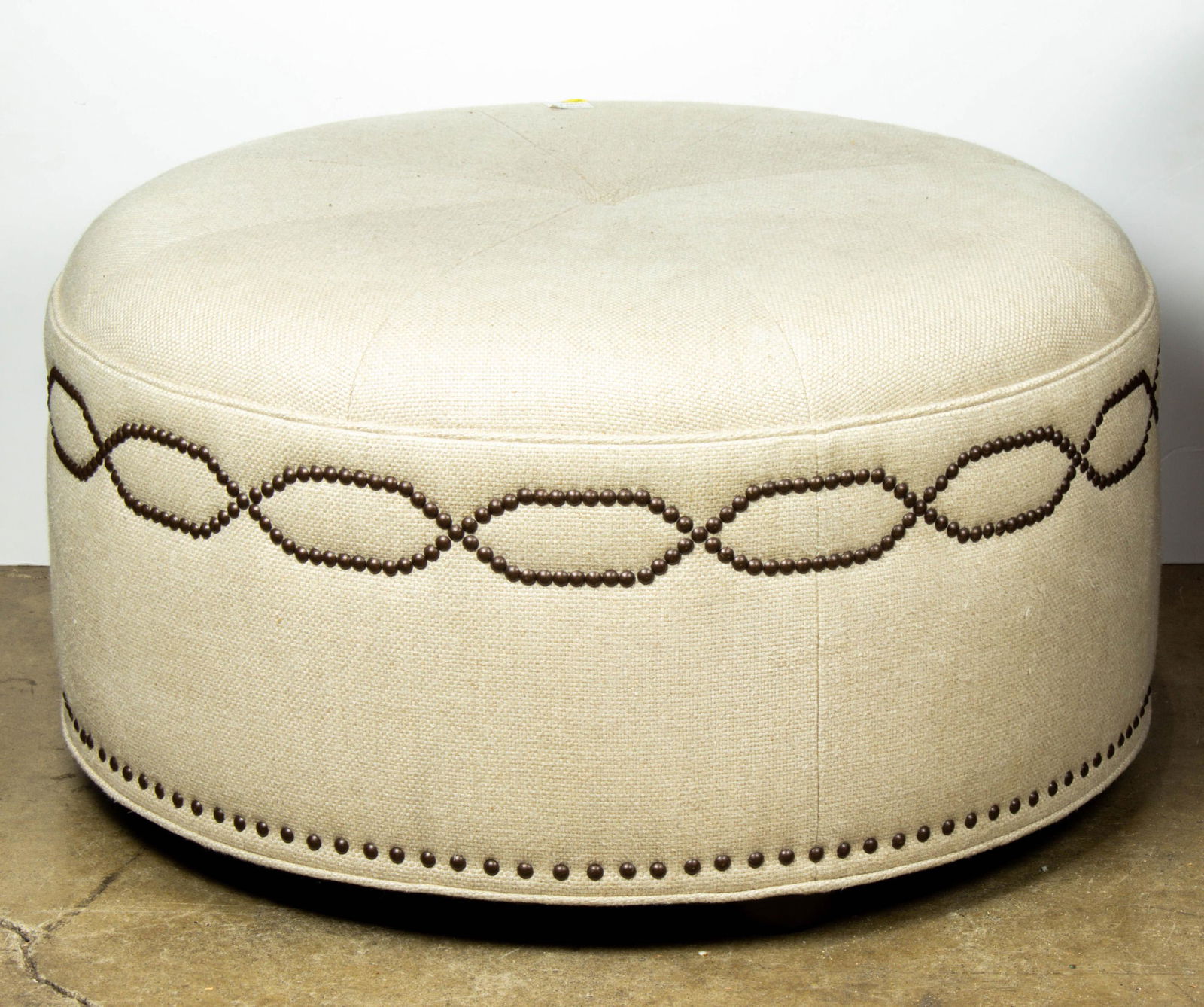 Large Michael Berman round ottoman accented with brass nail head trim: Large Michael Berman round ottoman accented with brass nail head trim, 16"h x 29"dia.