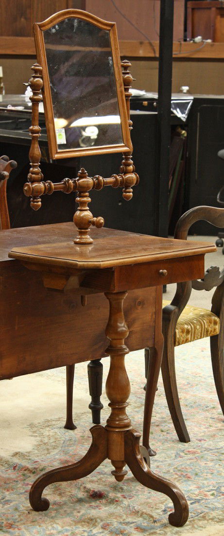 Victorian shaving stand: Victorian shaving stand, having an adjustable looking glass centering the turned U form support terminating at the single drawer case rising on a baluster turned standard terminating on a tripod base,