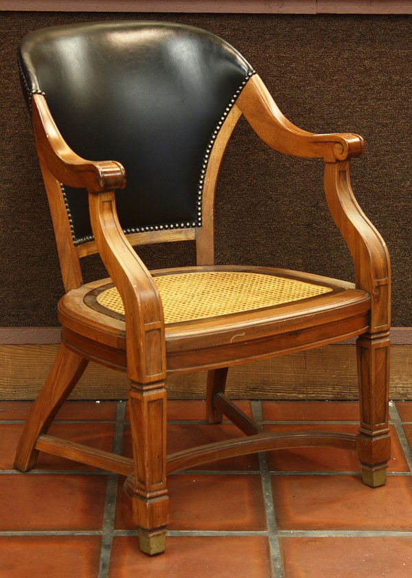Victorian style arm chair: Victorian style arm chair, having a padded back with brass head nails, having a cane seat foundation and rising on square legs terminating on tapered feet, 35''h x 25''w
