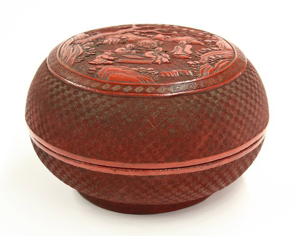 Chinese Cinnabar Lacquer Box: Chinese cinnabar lacquered circular box, late Qing/Republic period, the lid centered with a scene of scholars playing chess in a landscape with large pines, flowers and rock work set within a key-fret