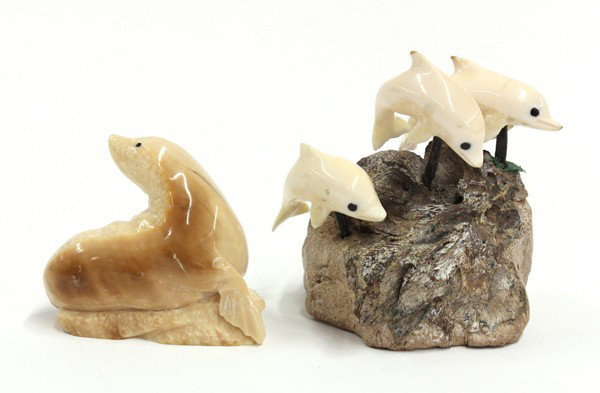 Two First Nation Marine Ivory Carvings: (Lot of 2) Alaskan or First Nation marine ivory carvings, the first of a sea lion, the base signed Eddy Syngor(?), 2.125''h; the second with three dolphins suspended above rockwork, signed Felix Wono-
