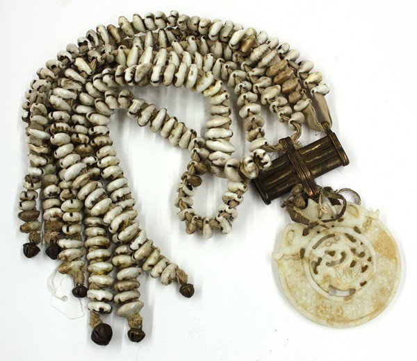 Chinese Hardstone Plaque/Strands of Seashells: Chinese folk decoration, consisting of a reticulated pale-green bi-form plaque formed by confronted dragons encircling a winged creature and suspended from an etched copper fitting of three conjoined 