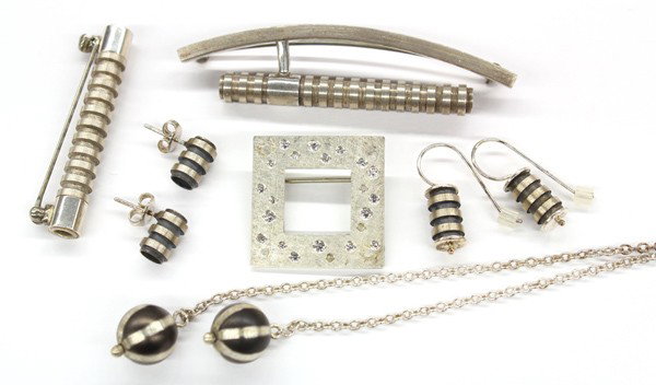 Miscellaneous sterling silver jewelry items: Collection of miscellaneous sterling silver jewelry items, including; two pairs of earrings; one framed CZ brooch; two pins and one chain necklace with hanging silver oxy balls. This lot has no buyer'