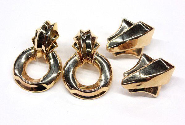 Two pairs of yellow gold earrings: Two pairs of 14k yellow gold hollow earrings, with Omega backs; one door knocker and one geometric fleur de lis. Total weight of earrings 22.3 grams. There is no buyer's premium on this lot.
