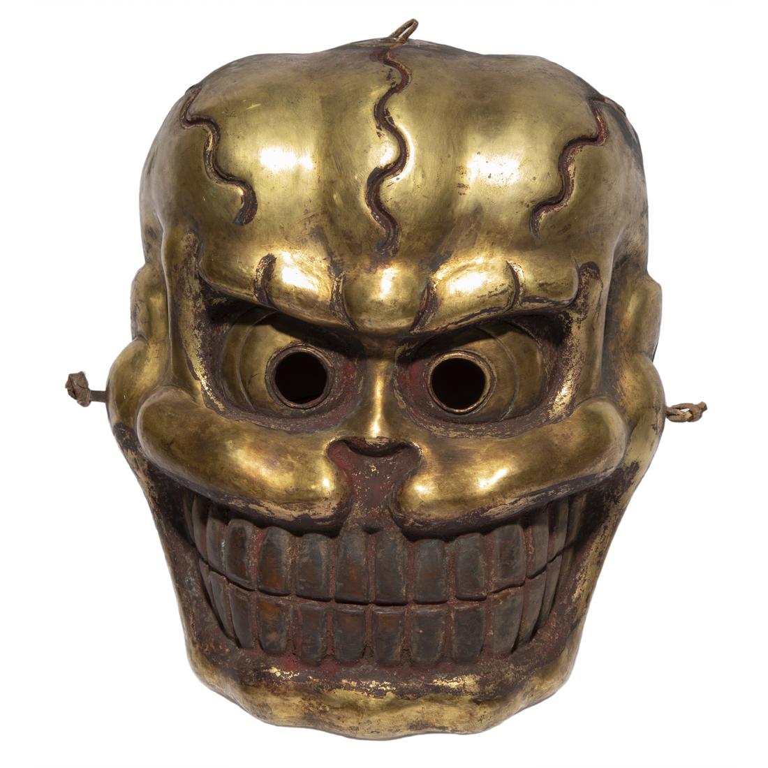 (lot of 2) Tibetan metal ritual masks: (lot of 2) Tibetan metal ritual masks, comprising a gilt metal mask of a skull with a fierce expression and grinning teeth and another skull mask with red painted eye sockets and grinning teeth, 10.75