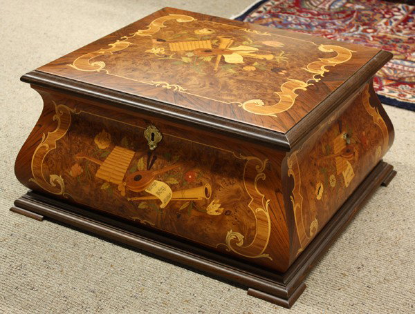 Porter music box with discs: (lot of 18) Porter ''Baroque'' music box, the Italian inlaid case executed in multiple exotic woods and having musical instruments and sheet music marquetry surrounding the bombe form case, the hinged
