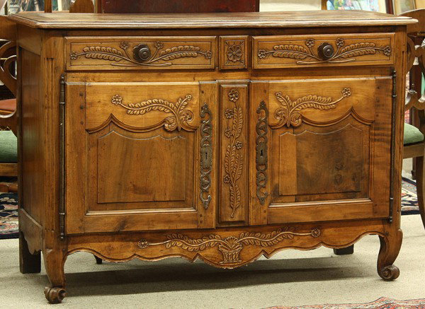 French Provincial buffet: French Provincial buffet, 18th Century, having a rectangular top above the two over two relief decorated case having floral reserves and rising on cabriole legs, 38.5''h x 55''w x 22''d (key in office