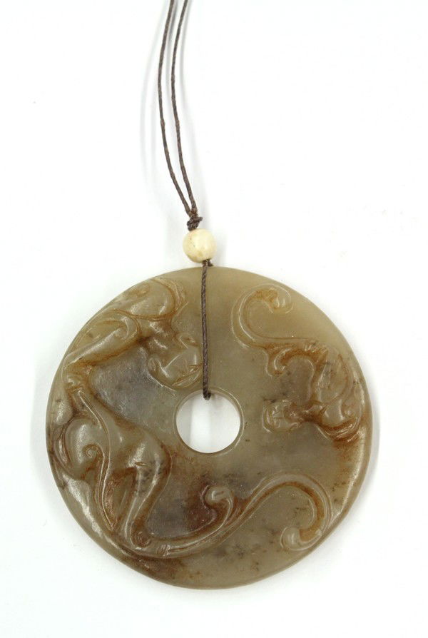 Chinese Zoomorphic Carved Jade Bi Disk: Chinese Han-style jade bi-disk, featuring a large sinuous chilong with a long bifurcated tail meandering besides a smaller similarly depicted zoomorph, the reverse overall bearing a raised rice grain