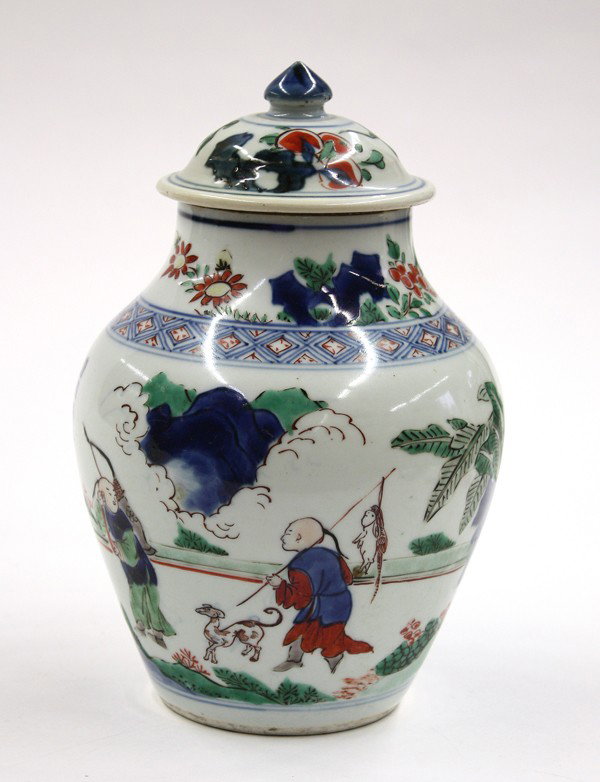 Chinese Wucai Porcelain Jar, Qing/Republic: Chinese wucai decorated small porcelain covered jar, of olive form featuring a scene of figures returning from a hunting trip with the young attendants carrying bow and arrow along with the catches, e