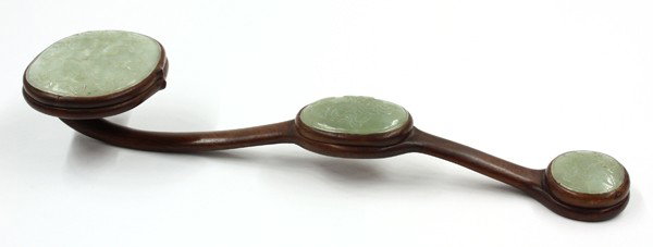 Chinese Wooden Ruyi Scepter with Jade Plaques: Chinese jade and wood ruyi scepter, Republic period, the contoured jichi-wood shaft set with three ovoid section green jade plaques, the largest panel carved with a fan and a hanging basket in relief,