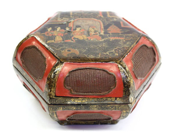 Chinese Lacquered Box: Chinese gilt and lacquered decorated box, of octagonal section decorated with figures seated in front of a screen set on a garden terrace, the canted sides featuring a woven pattern (losses), 6.3