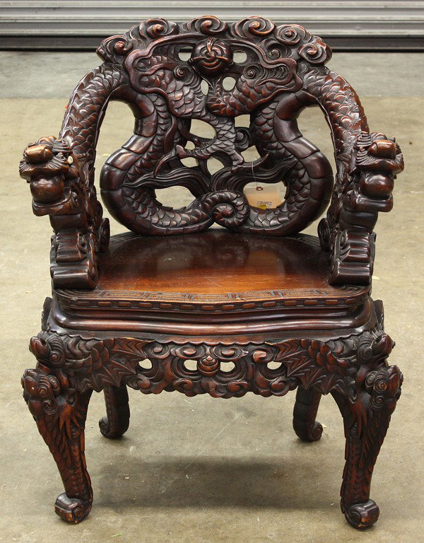 Japanese Wooden Export Armchair: Japanese export wooden armchair, Meiji period, dynamically sculpted with the heads of the pair of dragons as the arms of the chair, with a clutched jewel and the meandering bodies forming the intricat