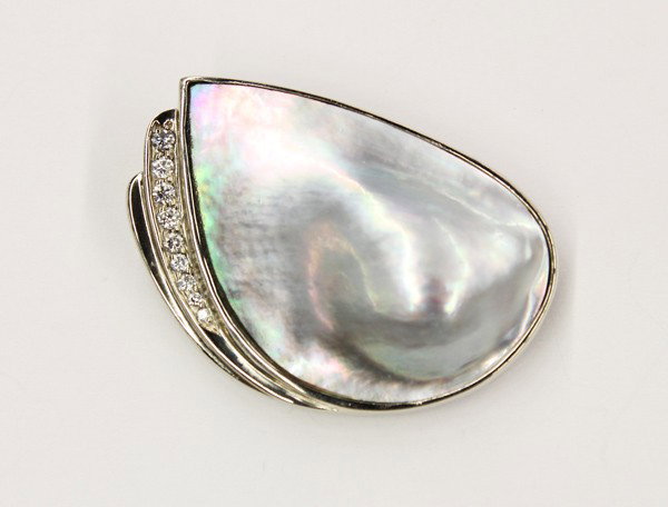 Tahitian mabe cultured pearl diamond brooch: Grey Tahitian mabe cultured pearl and diamond brooch; in white gold (stamped) 14K, having (9) full cut diamonds weighing 0.16 ct. There is no buyer's premium on this lot.