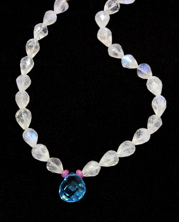 Moonstone briolette blue topaz sapphire necklace: Moonstone briolette necklace; having clasp of 18k yellow gold. Necklace is set with moonstone briolette beads, (1) London blue topaz and (2) pink sapphire smooth rondelles. Necklace length 17''. There