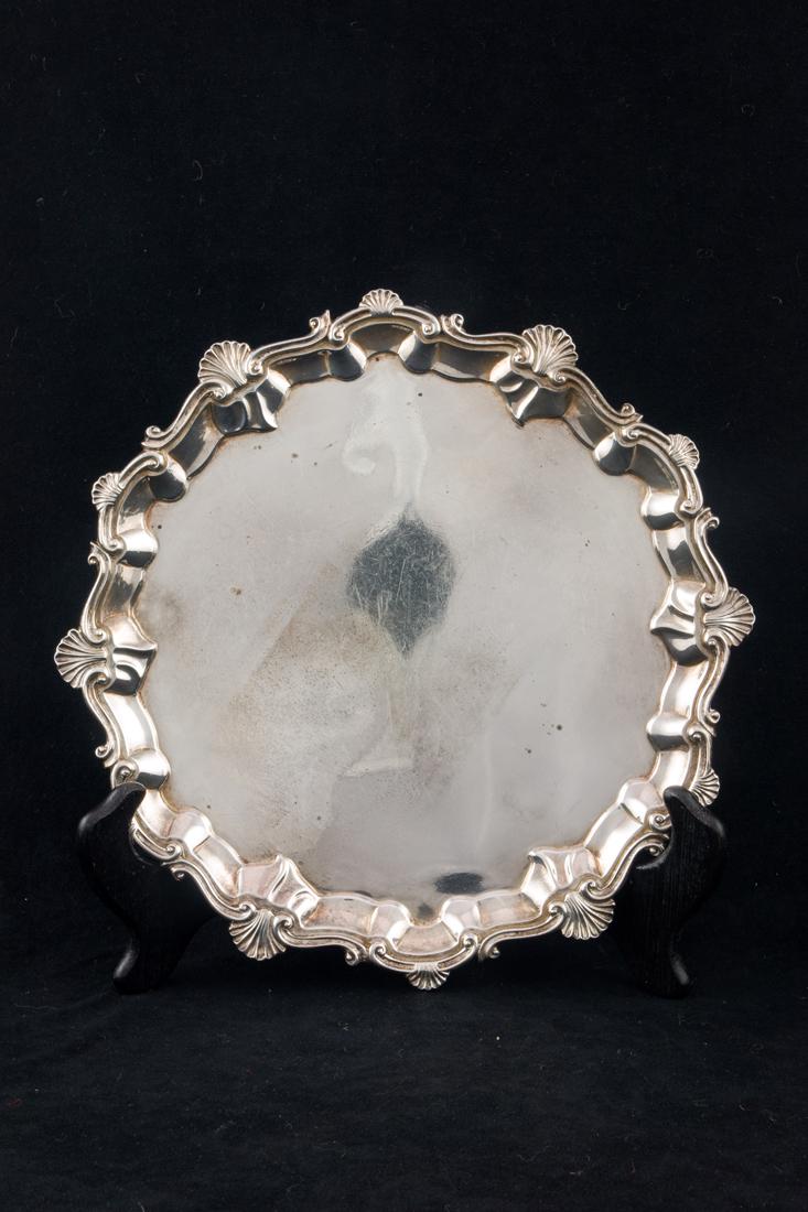 An Edwardian sterling salver, Charles Stuart Harris, London, circa 1902: An Edwardian sterling salver, Charles Stuart Harris, London, circa 1902, the dishform tray with a scroll and shell scalloped rim, 10"d, 21 toz