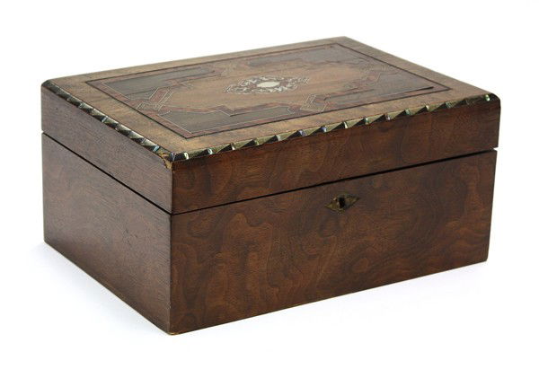 Inlaid dresser box: Continental inlaid dresser box circa 1860, executed in mixed woods, the hinged top having a geometric medallion surrounded with an ebonized and mother of pearl banding, and opening to reveal the origi