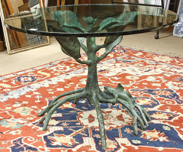 Brasseur style dining table: Jacques Duval Brasseur style dining table, with a circular glass surface, raised on an organic verdi patinated figural tree form base with an ambulatory fish on the limbs, 31.5''h x 47.5''w