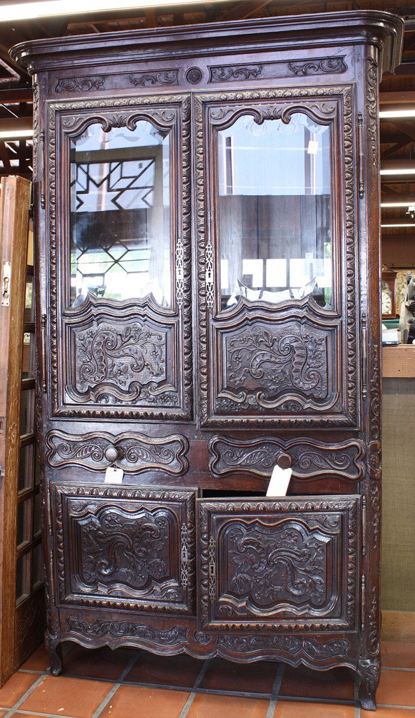 Provincial oak cabinet: French Provincial carved oak cabinet, circa 1820, executed in the Louis XV taste, the molded cornice above the double doors having bevelled glass panels surmounting the raised panelled reserves having