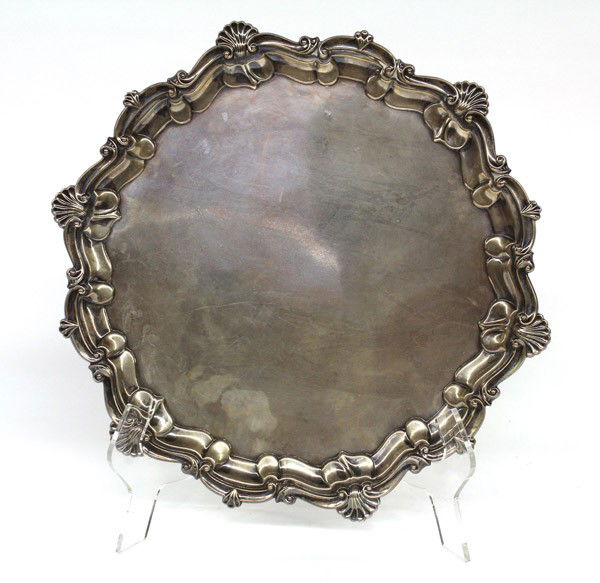 English sterling footed salver: English sterling silver footed salver, by Robert Pringle and Sons, London, 1904-1905, promoting an over-all chased hand work of alternating scrolls and clam shells resting on four claw on ball feet, 1