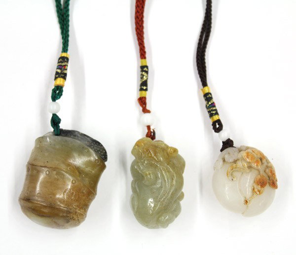 Group of Chinese Jade Toggles: (Lot of 3) Chinese jade toggles, consisting of a recumbent mythical beast of dark celadon hue with russet splashes to its head; a white peach with pair of bats and cash coins picked out from the russe