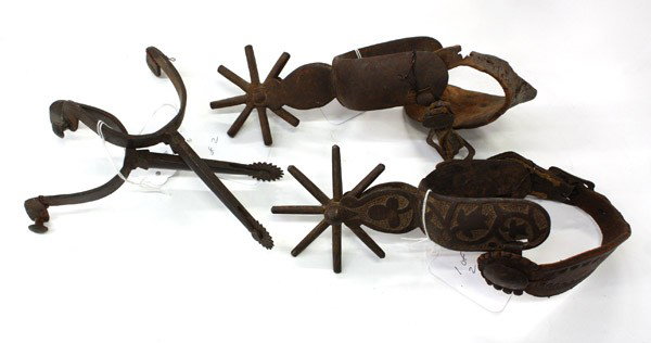 Western spurs: Three shelves having twenty pairs of assoicated Western spurs of wrought iron, brass and copper, some with silver overlay, in various styles including Early California, Charro, Colorado, and Mexico