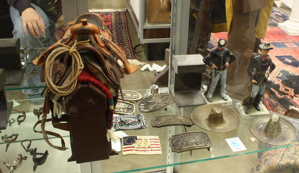 Collection of western items: ( lot of 28) Associated western decorative items, including three Capo di Monte Civil War figurines, iron railroad bookends, miniature salesman sample saddle, buckles, sombrero ashtrays, spur key ring