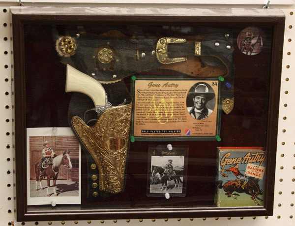Joe Mara Sweetheart of the Rodeo: Gene Autry collection presented in a shadow box showing a toy gun rig, postcard, collector's card, and button, 16''h x 20''w