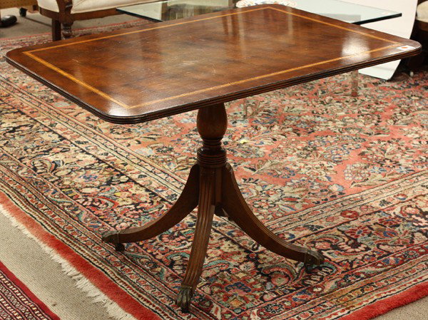 Regency style breakfast table: Regency style breakfast table circa 1920, having a band inlaid tilt top rising on a turned standard terminating on fluted outswept feet terminating on brass capped casters 30''h x 40''w x 30''d