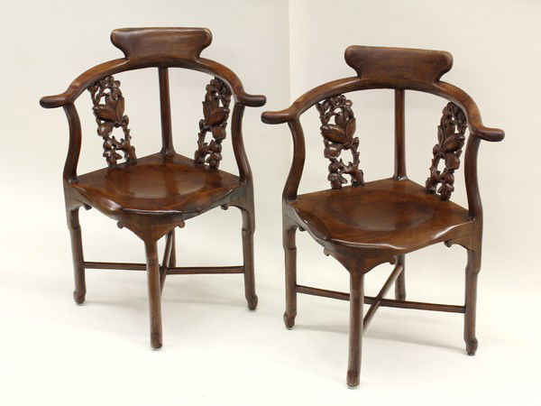 Four Chinese Wooden Corner Chairs: (Lot of 4) Chinese hardwood corner chairs, each with a back rest suspended from a horseshoe-form toprail accented with a pair of panels reticulated with flowering magnolia, along with shaped posts set