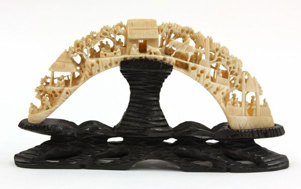 Chinese Small Ivory Tusk: Chinese carved small ivory tusk, reticulated with a village scene of figures amid villa and trees, with wood stand, ivory: 7.75''w