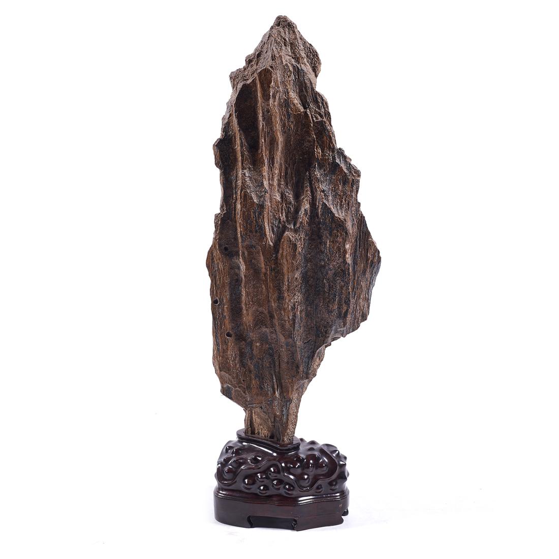 Chinese petrified wood scholar's rock: Chinese petrified wood scholar's rock, the of vertical form and rising to a pointed peak, Jiangnan style wood stand, overall height 29".