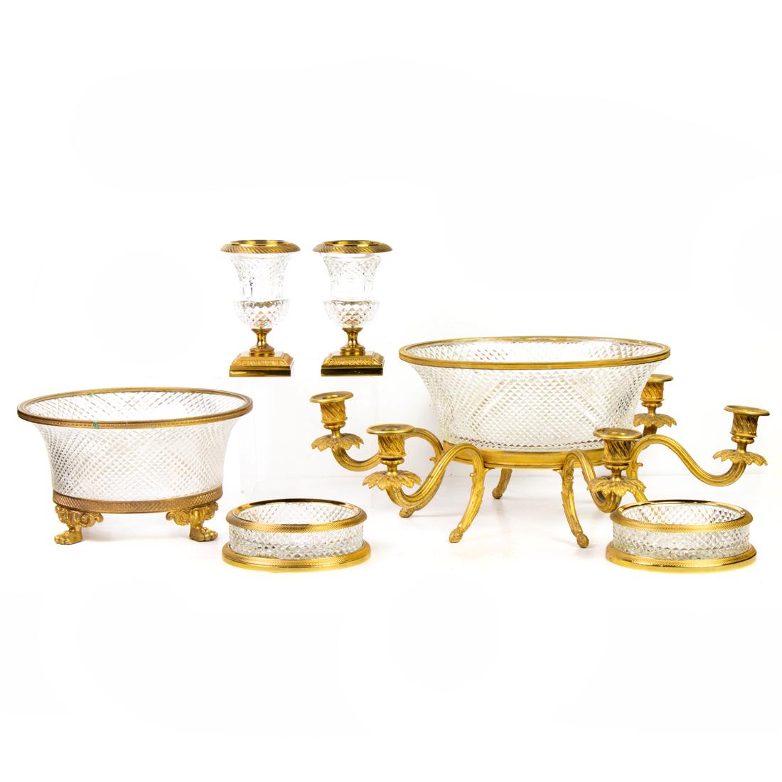 (Lot of 6) Grouping of Neoclassical style gilt bronze mounted cut glass table articles: (Lot of 6) Grouping of Neoclassical style gilt bronze mounted cut glass table articles, comprising six-light oval centerpiece, greatest 19"l x 7.75"h; bowl raised on monopodia supports, 5.5"h x 10"dia