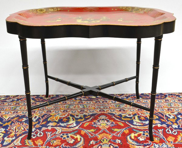 English tole peinte tray: English Tole Peinte tray circa 1870, having gilt chinoiserie decoration on a crimson ground with gilt highlights, rising on a later ebonized stand having faux bamboo turned legs terminating on outswep
