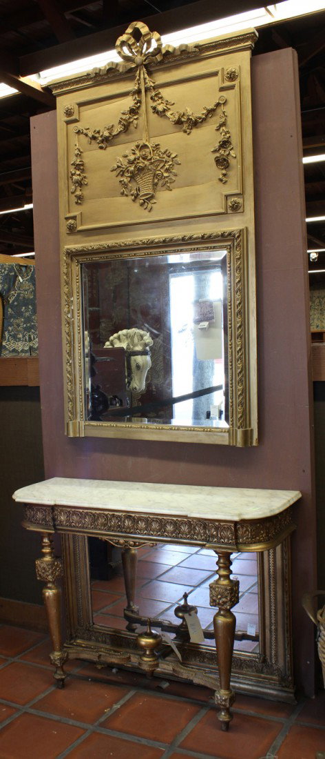Neoclassical style console table and mirror: Neoclassical style console mirror, the giltwood trumeau top having a bow and swag decorated top above the bevelled looking glass surmounting the marble top base having an acanthus decorated frieze and