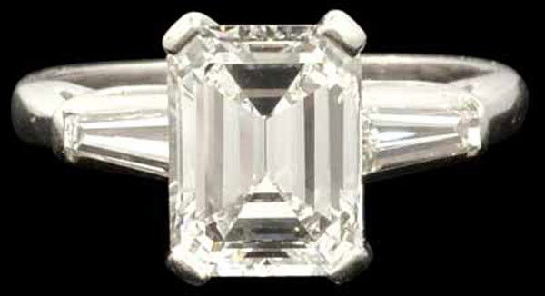 Emerald cut diamond platinum ring: Diamond ring; of platinum, featuring (1) emerald cut diamond, measuring 8.98 x 6.93 x 4.49mm, (displaying: E-F color, VVS2 clarity), weighing approximately 2.43 cts, accentd by (2) tapered baguette-cu