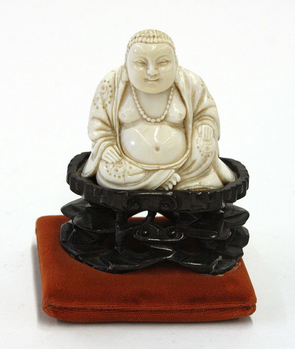 Chinese Small Ivory Figure, Budai: Chinese small ivory figure of Budai, well carved and incised in a seated pose with his patterned robes open to expose his large belly, the smiling face framed by a coiffure of small curls, the base in