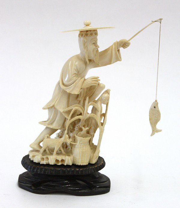 Chinese Ivory Figure of a Fisherman: Chinese ivory figural carving, featuring a fisherman wearing a wide removable straw hat and standing with a fish dangling from a short pole, a small child to the front pulling up a fishing net and a b
