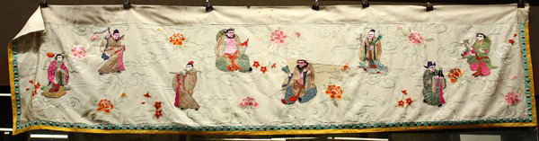 Chinese Embroidered Banner, Eight Immortals: Chinese embroidered horizontal banner, of the Eight Immortals amid peony sprays and executed in metallic couching and satin stitches of colored silk threads on a white satin silk ground, the border ap