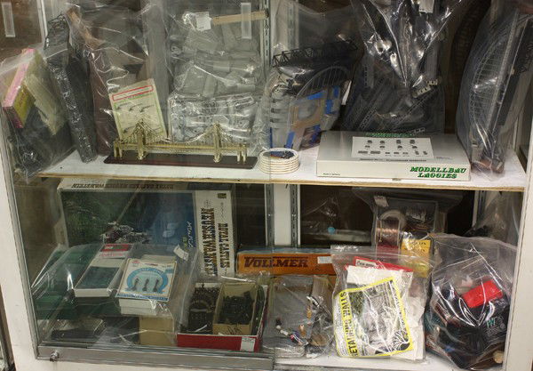 Two shelves of railroad accessories: Two shelves of associated railroad accessories in various scales including trestle bridges, transformers, wires, lamp posts, makers include Modelllbau Laggies and Marklin