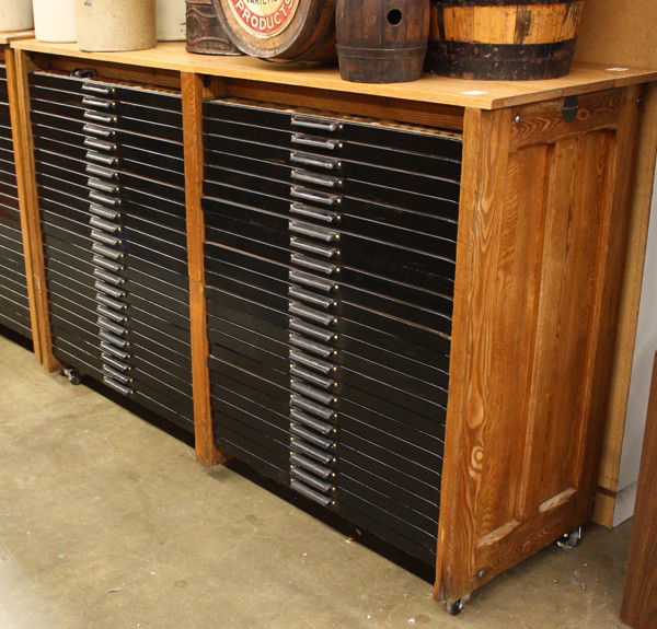 Print shop flat file: Hamilton print shop flat file with forty-eight drawers, each draweer designed to hold multiple lead types, housed in an oak case and raised on casters, 46.25''h x 72.25''w x 23.5''d