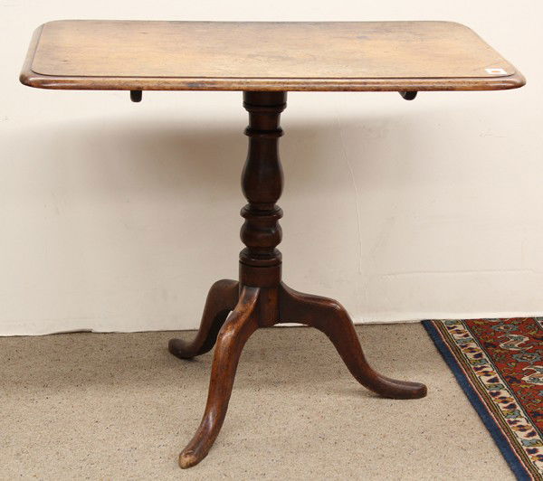 Chippendale tea table: Chippendale tilt top tea table circa 1770, the single board rectangular top having a molded edge above a baluster turned standard rising on a tripod base terminating on snake feet, 9.5''h x 36''w x 24