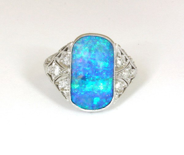 Opal diamond Edwardian style platinum ring: Opal and diamond Edwardian style ring; of platinum, featuring a saddle cabochon cut blue green opal with matrix base, accented by (20) round single cut and (10) round full cut diamonds. total diamond 