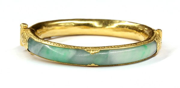 Jade yellow gold side hinged bangle bracelet: Jade side hinge bangle bracelet, with safety chain; mounted in 22k yellow gold. Total bracelet weight 44.5 grams
