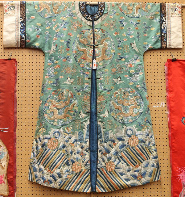 Chinese Woman's Green Ground Robe with Dragons: Chinese woman's green ground silk robe, with a button front and featuring eight dragon roundels worked in gilt-wrapped threads and with the ground scattered with colorful clouds, cranes, bats, shou em