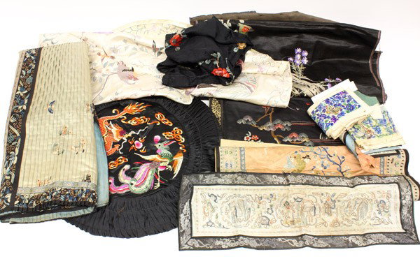 Group of Chinese Textiles: (Lot of 12) Assortment of Asian and Chinese textiles, including an orange-ground child's vest embroidered with a pair of phoenixes, one panel of a Han woman's pleated skirt decorated with children in 