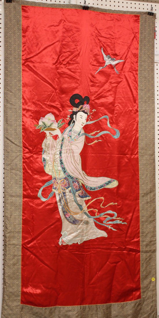 Chinese Silk Hanging with Magu: Chinese red silk hanging, featuring the female immortal Magu with an embroidered face and elaborate coiffure, holding a platter of peaches and in robes with silk appliques, 71.5''h x 34.5''w
