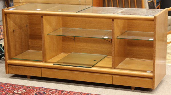 Paul Laszlo, Brown Saltman oak display cabinet: Paul Laszlo for Brown Saltman mahogany display cabinet, with a glass surface, below three glass sliding doors, the interior with three glass shelves, below three single drawers, the right drawer retai