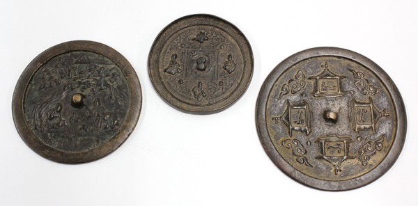 Group of Three Chinese Bronze Mirrors, Figures: (Lot of 3) Chinese circular bronze mirrors: the first cast with four pavilions, each with a scholar playing a qin and further framed by scrolling clouds; second with a scene of two scholars below a le