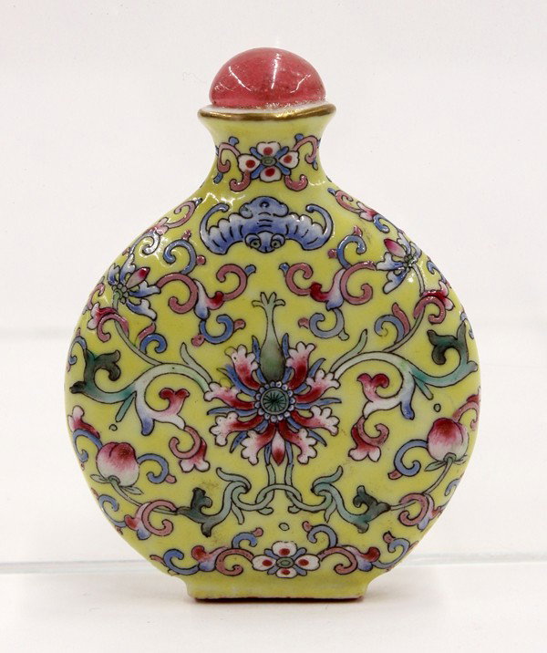 Chinese Yellow Enameled Porcelain Snuff Bottle: Chinese enameled yellow ground porcelain snuff bottle, of flattened circular form decorated with lotus blossoms and peaches issuing from multiple colored tendrils all below a pair of blue bats, the ba