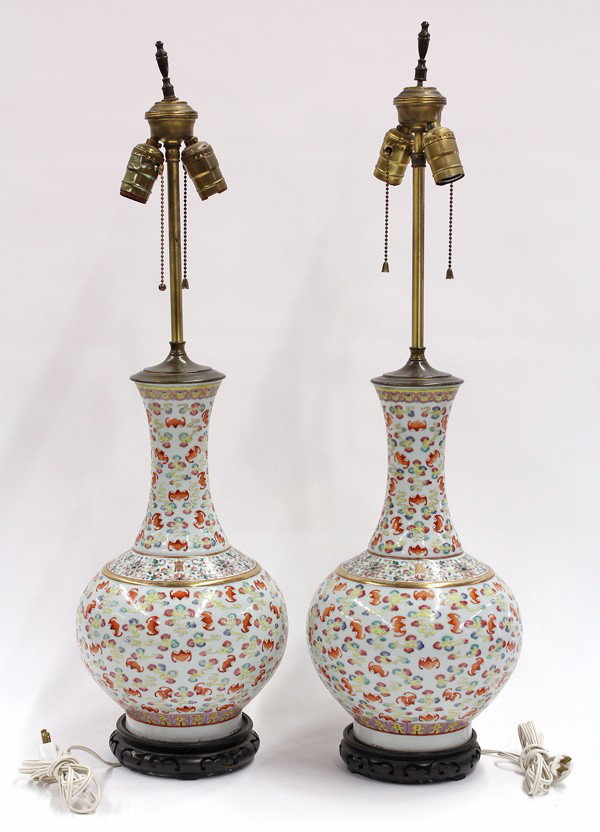 Chinese Enameled 'Hundred Bat' Porcelain Vases: Pair of Chinese polychrome enameled porcelain vases, now mounted as lamps, early 20th century, each with a waisted long neck and globular body brightly decorated with red bats soaring amid multi-color